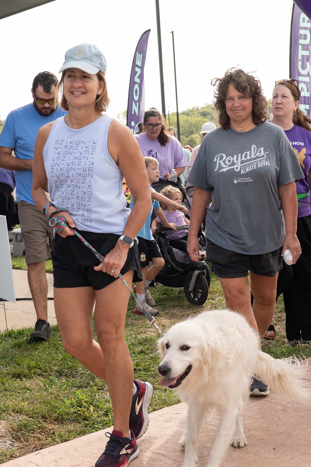 Participant walking with a white dog during the Walk to End Alzheimer’s in St. Joseph, Missouri.