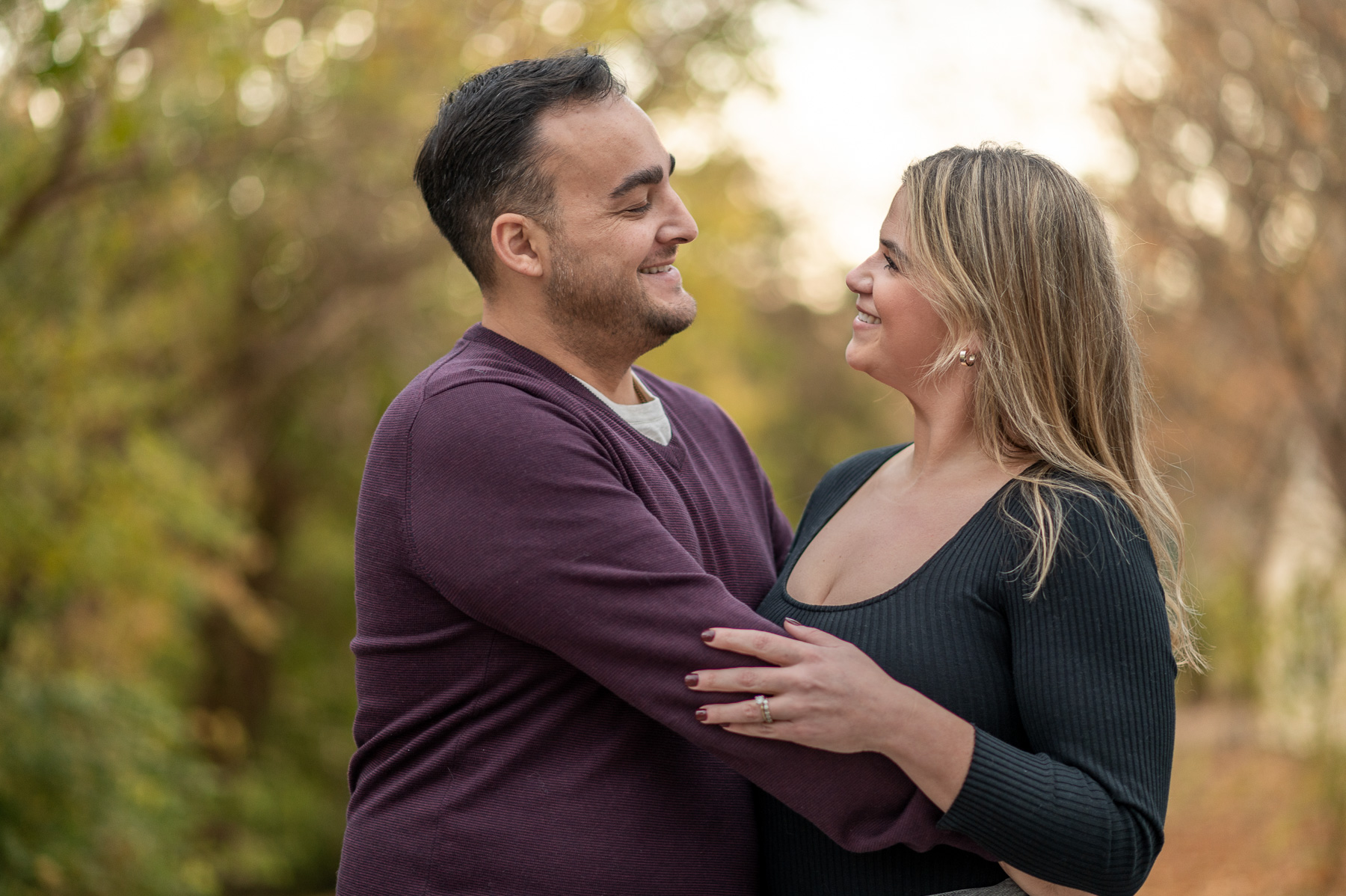 Romantic autumn portrait of a couple embracing outdoors in St. Joseph, Missouri during golden hour.